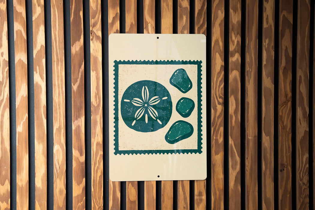 A sign with a floral design and four green stones is displayed on a wooden wall.