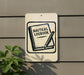 a sign that reads "Nautical Logbook" with a pencil and a book illustration, mounted on a wall.