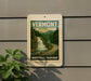 A vintage-style sign for Vermont Waterfall Parkway is displayed on a gray wall, featuring a scenic image of a waterfall surrounded by trees.