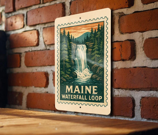 A metal sign with a waterfall and forest scene is mounted on a brick wall.