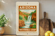A framed poster of the Waterfall Loop in Arizona hangs on a wall, surrounded by kitchen utensils and a potted plant.