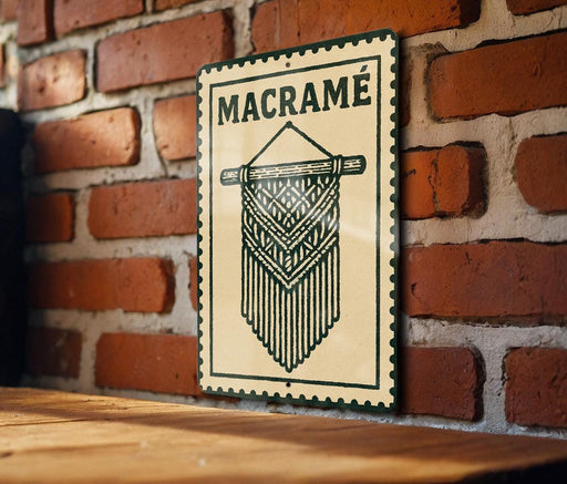 A metal sign with the word "MACRAME" on it is mounted on a brick wall.