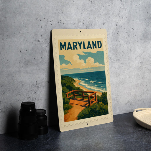 A framed poster of a scenic beach view with a bench and ocean in the background, placed on a gray countertop next to some black camera lenses.