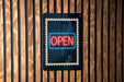 A neon sign that says "OPEN" is displayed on a wooden wall.