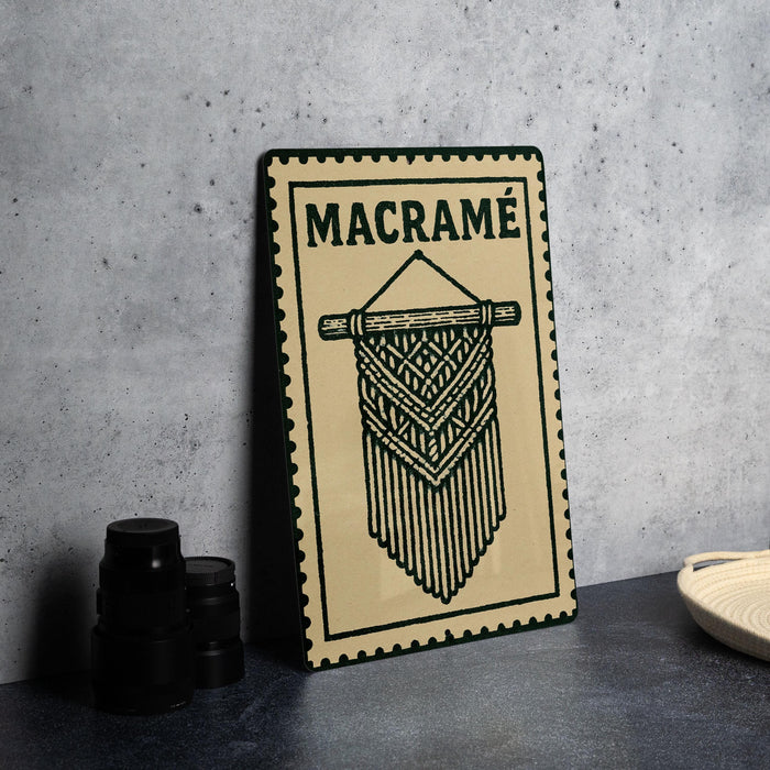 a decorative sign with the word "MACRAME" on it, placed on a table next to some black camera lenses.