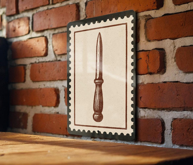 a wooden table with a framed picture of a knife hanging on the wall above it.