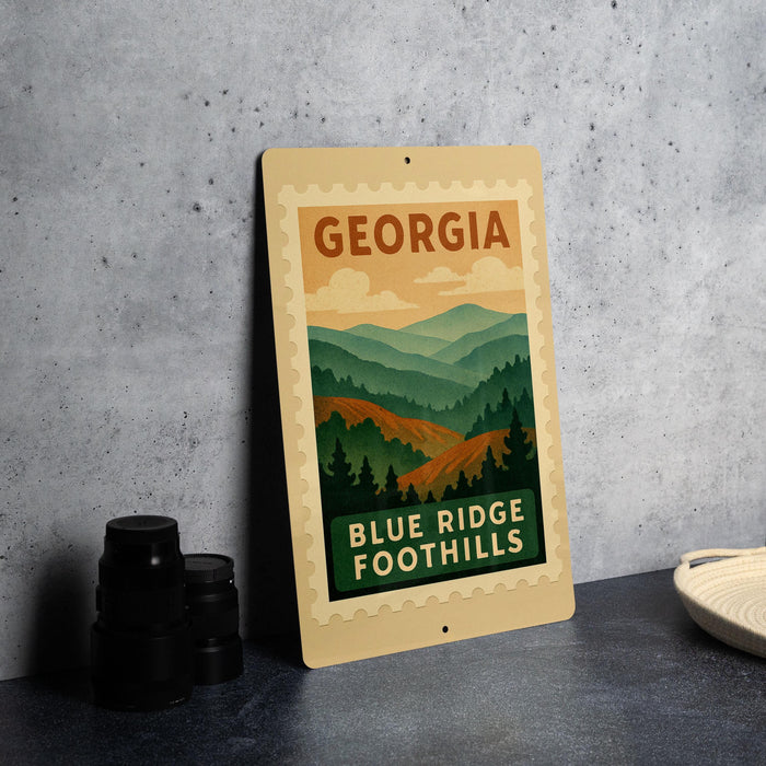 A metal sign with the text "GEORGIA" and "BLUE RIDGE FOOTHILLS" is displayed on a table, along with some black camera lenses.