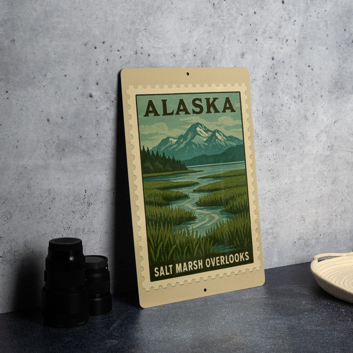 A framed poster of a scenic Alaska landscape, featuring mountains, a river, and lush vegetation, is displayed on a wall.