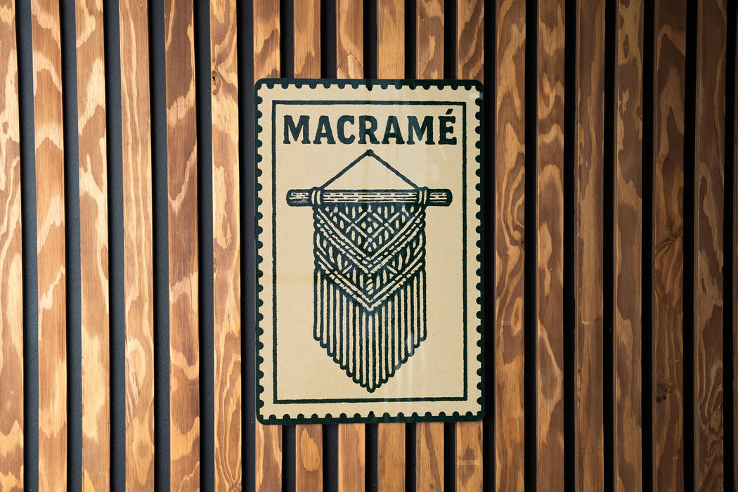 a wooden wall with a decorative sign that reads "MACRAME" in bold black letters.