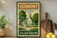 A vintage-style sign for Vermont Village Greens, featuring a church and a town square, is displayed on a shelf next to a wooden cutting board and a potted plant.