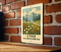 A vintage-style sign for the Utah Wildflower Meadows Trail, featuring a mountain landscape with wildflowers and a winding path.