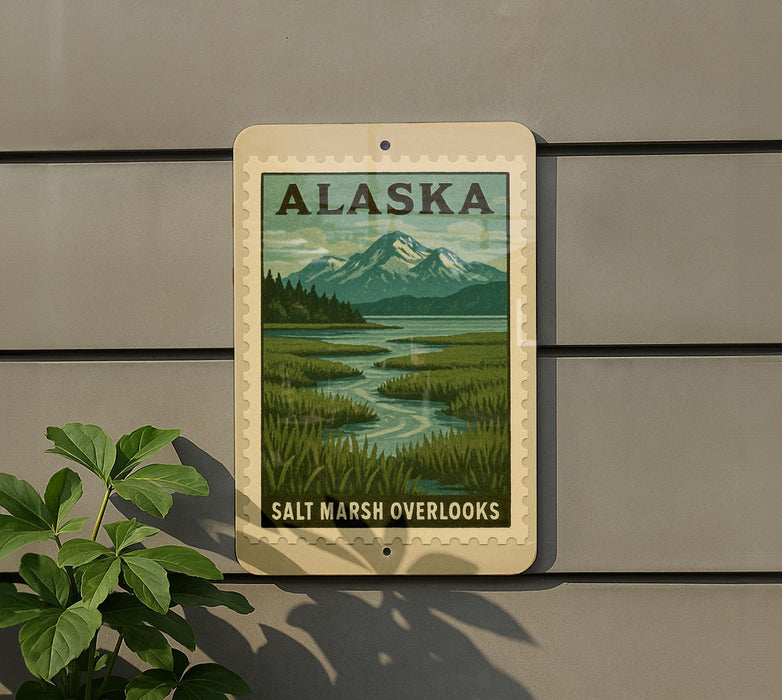 A sign for Salt Marsh Overlooks in Alaska, featuring a scenic landscape with mountains, a river, and lush vegetation.