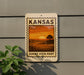 A sign for Kansas Sunset Vista Point is displayed on a wall, featuring an illustration of a sunset over a field.