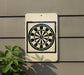 a white sign with a black and white dartboard design on it, mounted on a wall.