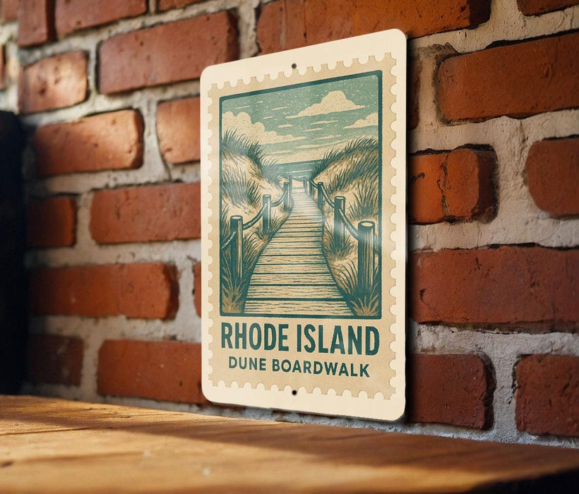 A sign for the Rhode Island Dune Boardwalk is displayed on a brick wall.