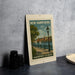 A framed poster of a harborfront esplanade in New Hampshire, featuring a scenic view of the harbor with sailboats and a lamppost.