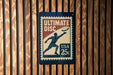 A sign that reads "Ultimate Disc" with a 25c postage stamp, mounted on a wooden wall.