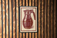 A red and white illustration of a coffee mug is displayed on a wooden wall.