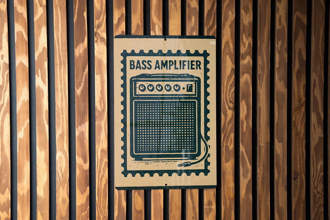A sign with the word "BASS AMPLIFIER" printed on it is mounted on a wooden wall.