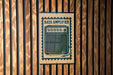 A sign with the word "BASS AMPLIFIER" printed on it is mounted on a wooden wall.