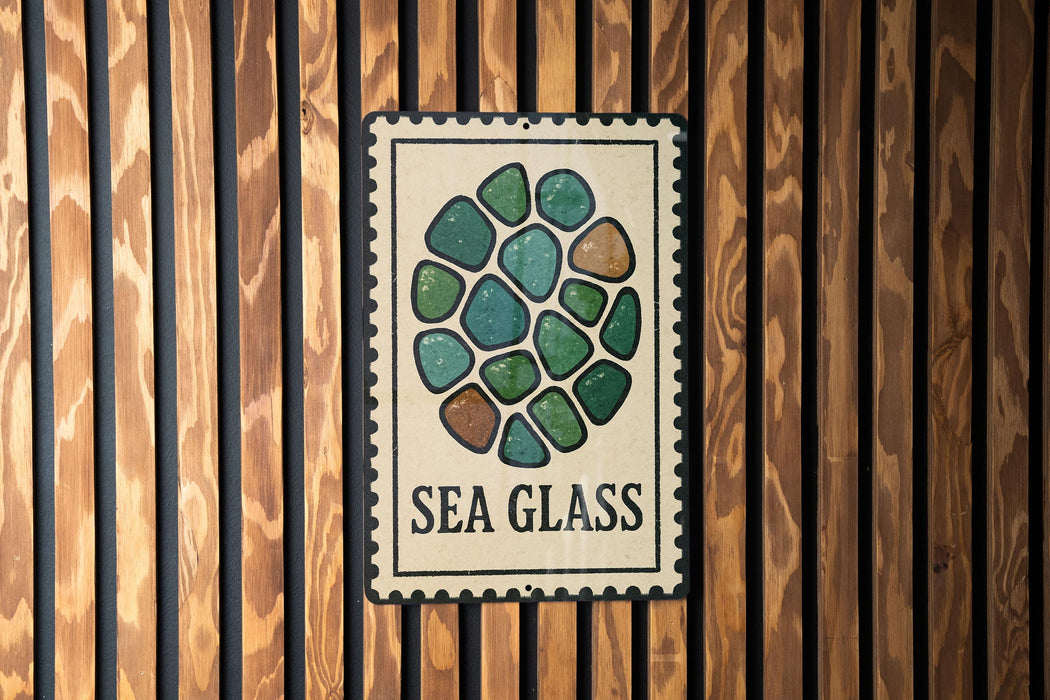 a sign with a circular design of green and brown stones, mounted on a wooden wall.