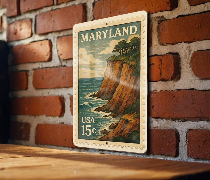 A vintage Maryland postage stamp is displayed on a brick wall, featuring a scenic cliffside landscape with the ocean in the background.
