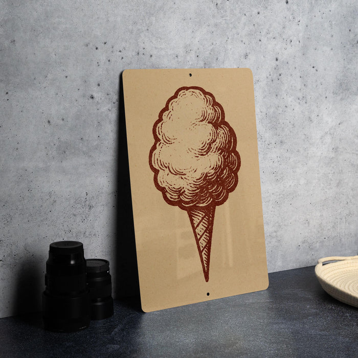 a sign with a drawing of a cotton candy on it, placed on a table next to some black containers.