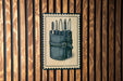 A framed illustration of a knife set is displayed on a wooden wall.