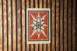 a sign with a stylized design, including a graphic of an atom and rays emanating from it, mounted on a wooden wall.