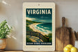 A framed poster of a scenic ocean view, featuring a wooden bridge and a beach, is displayed on a shelf next to a wooden cutting board and a potted plant.