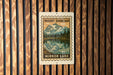 A framed image of a mountain lake, with the text "MOUNT SHUKSAN" and "MIROR LAKE" printed on it, is displayed on a wooden wall.