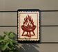 a sign with a red and white design depicting a fire pit or grill with flames.