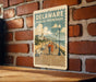 A vintage-style poster of a boardwalk in Delaware, featuring a couple walking along the boardwalk and a scenic view of the ocean and buildings in the background.