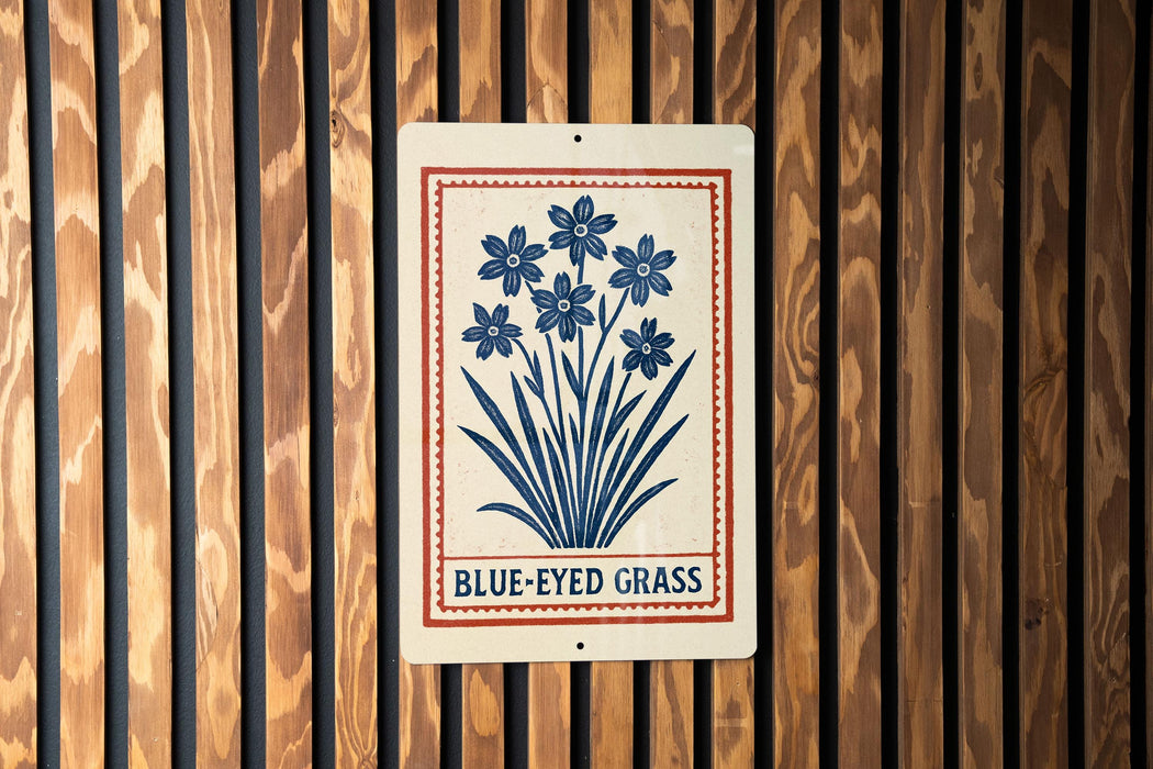 A sign with a blue flower design and the text "BLUE-EYED GRASS" is displayed on a wooden wall.