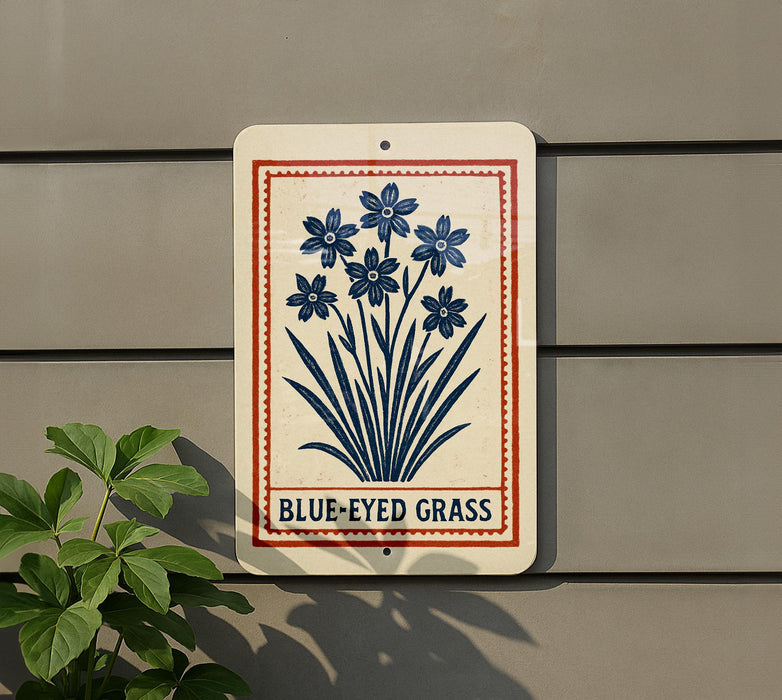 a sign with a blue flower design and the text "BLUE-EYED GRASS" on a gray wall.