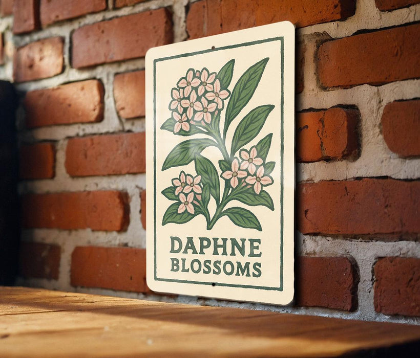 a sign with a floral design and the text "DAPHNE BLOSSOMS" displayed on a brick wall.