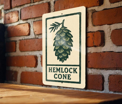 A sign with the text "HEMLOCK CONE" is displayed on a brick wall, with a wooden table below it.