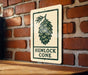 A sign with the text "HEMLOCK CONE" is displayed on a brick wall, with a wooden table below it.
