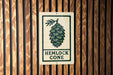 A sign with the text "HEMLOCK CONE" is displayed on a wooden wall.