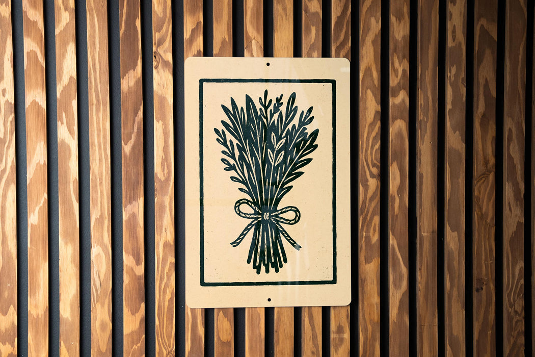 a sign with a black and white illustration of a bunch of flowers or plants, mounted on a wooden wall.