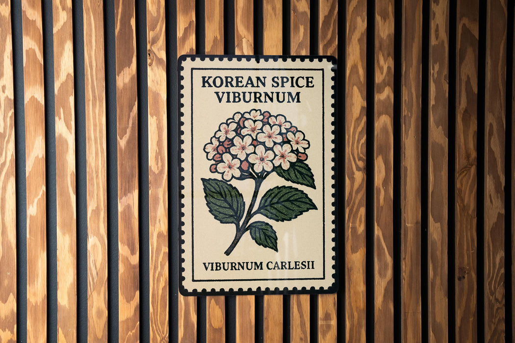 A decorative poster with a floral design and text, mounted on a wooden wall.