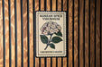 A decorative poster with a floral design and text, mounted on a wooden wall.