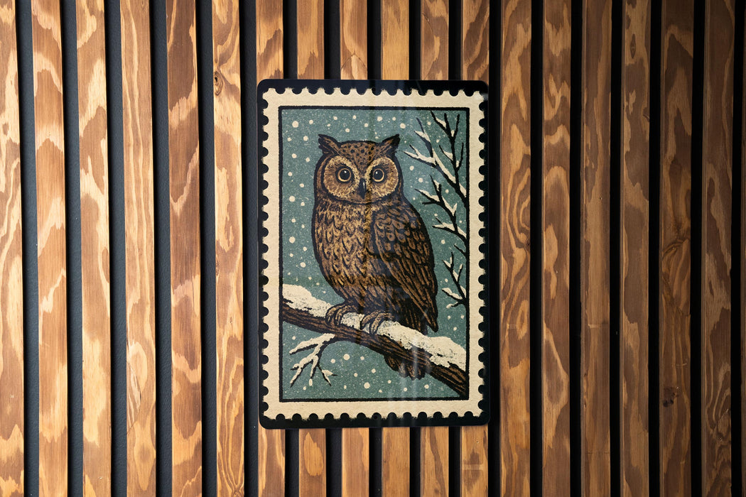 A framed image of an owl is displayed on a wooden wall.
