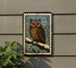 A framed image of an owl perched on a branch, with snowflakes in the background, is displayed on a wall.