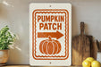a sign that reads "Pumpkin Patch" with an arrow pointing to the right, placed on a shelf next to a wooden cutting board and some lemons.