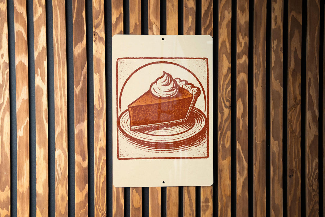 A sign featuring a pie with whipped cream on top, mounted on a wooden wall.