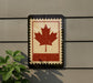 a Canadian flag, which is a red maple leaf, mounted on a wall.
