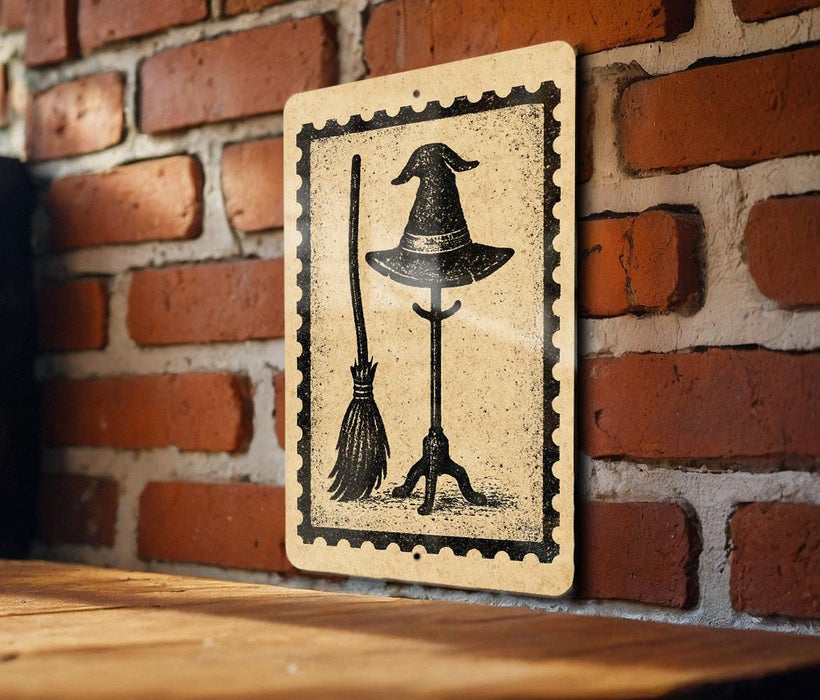 A sign featuring a witch's hat and broom is mounted on a brick wall.