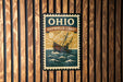 A vintage-style sign for the Ohio Shipwreck Coast, featuring a ship illustration and the text "OHIO SHIPWRACK COAST" prominently displayed.