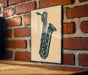 A metal sign featuring a saxophone illustration is mounted on a brick wall.